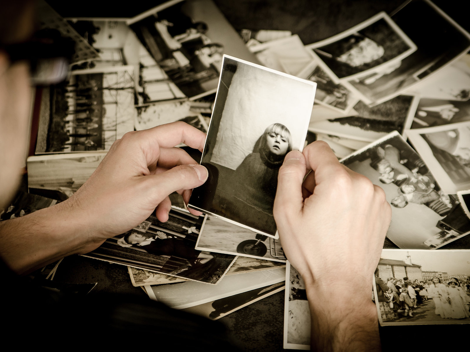 Hands sorting a pile of black and white photographic prints